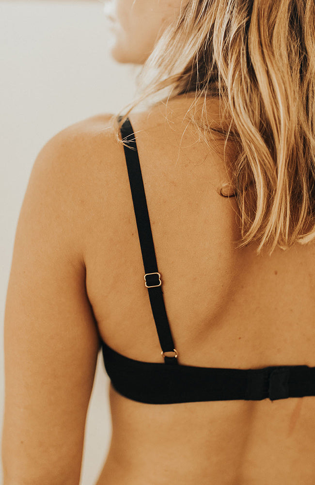 Gros plan sur le dos d'un soutien gorge, bretelles réglables avec des accessoires dorés
