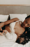 Femme allongée avec soutien-gorge d'allaitement en coton bio crème, en train d'alléter