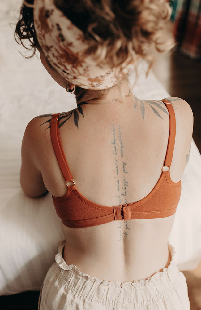 Femme de dos portant un soutien-gorge d'allaitement de couleur terracotta