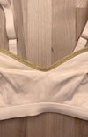 Soutien-gorge d'allaitement posé à plat, couleur crème, détails dorés
