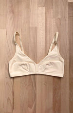 soutien-gorge posé à plat sans rembourrage et sans armature, de couleur crème